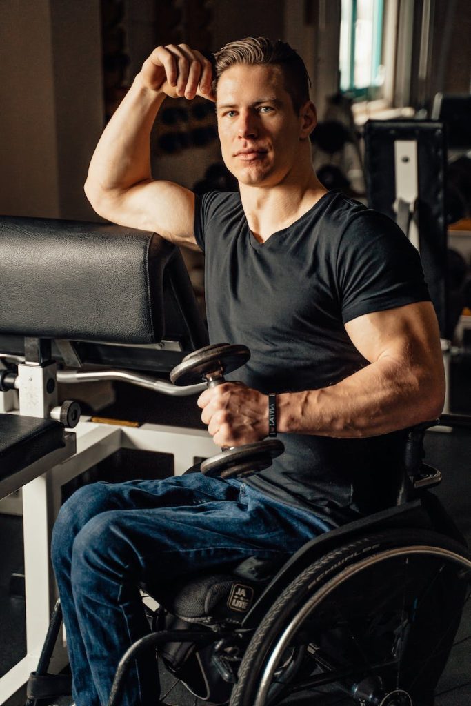 man in wheelchair holding a dumbbell